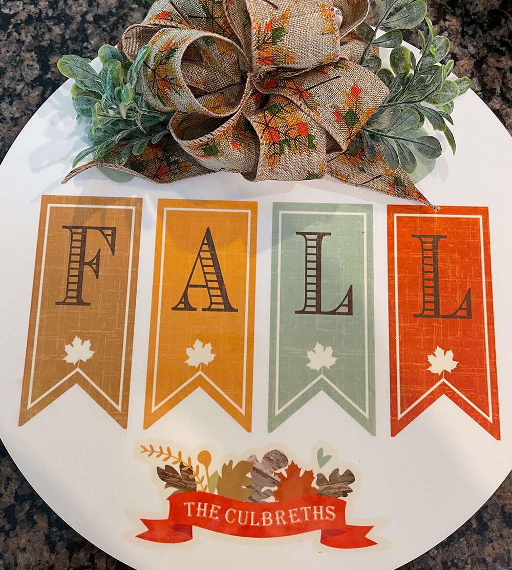 Large round home decor personalized with "Fall", each letter being in a pendant image, "The Culbreths" and a fall theme ribbon at the top