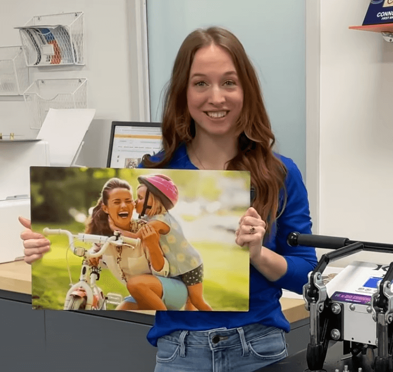 Woman holding a picture of a parent and child with a bike