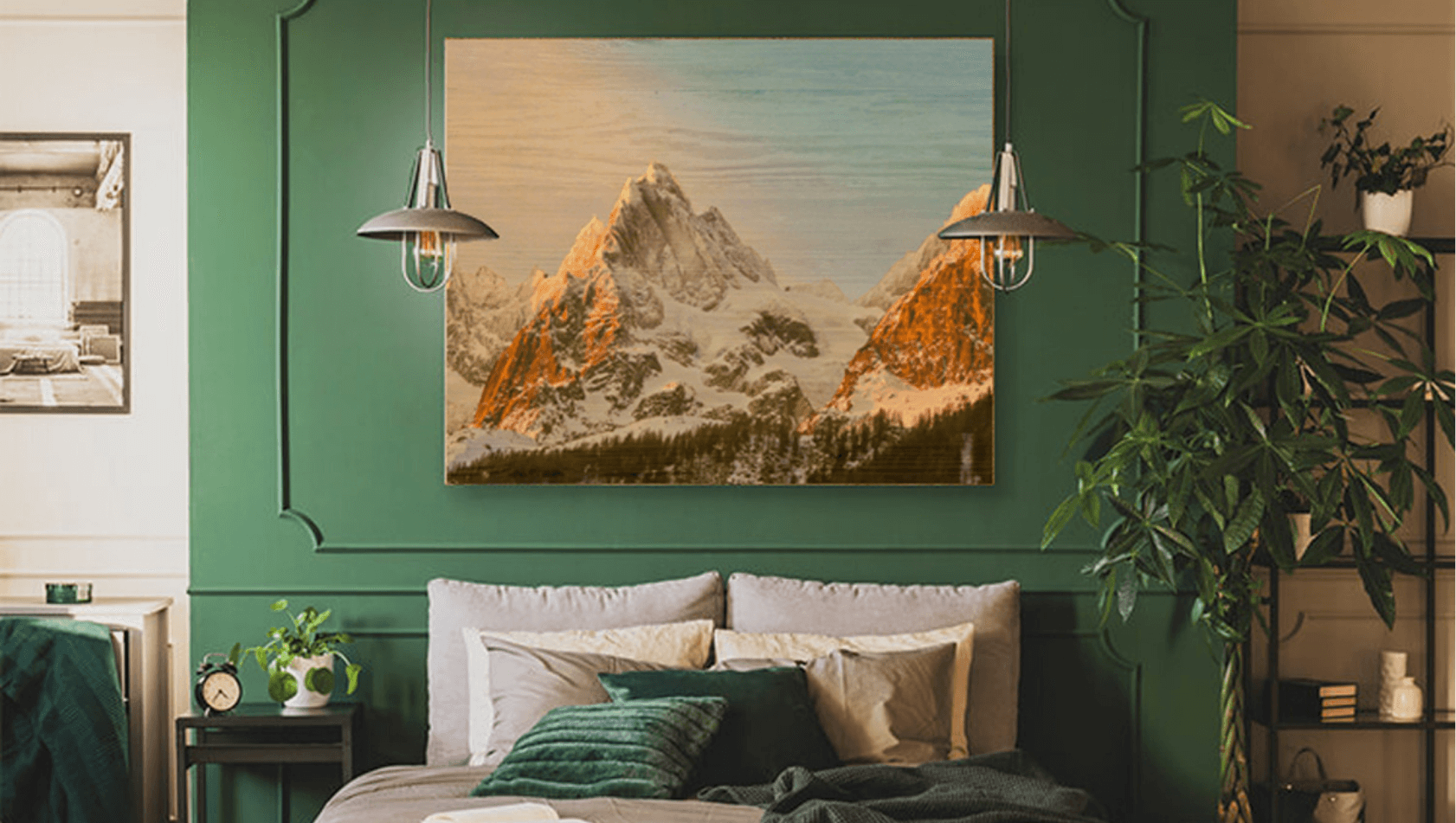 picture of mountain tops hanging on wall with 2 hanging lamps on either side, a bed with cushions beneath the picture.