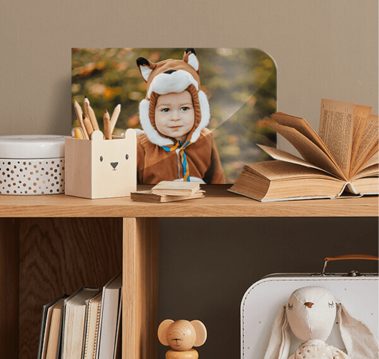 Bookshelf with a variety of books and pencils with a picture of a child in a costume
