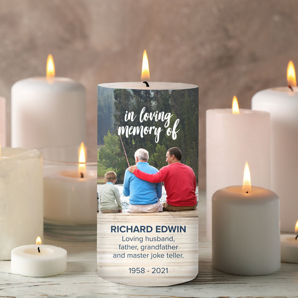 personalized memorial candle on a table with other white candles
