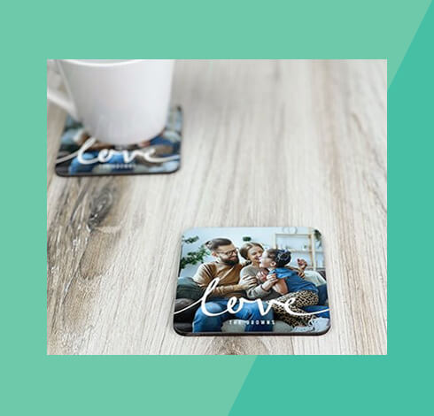 two coasters customized with a family photo, both sitting on a table, one with a mug on it